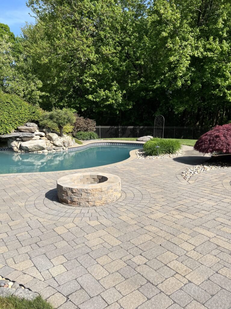 Restored paver pool patio with a round fire pit
