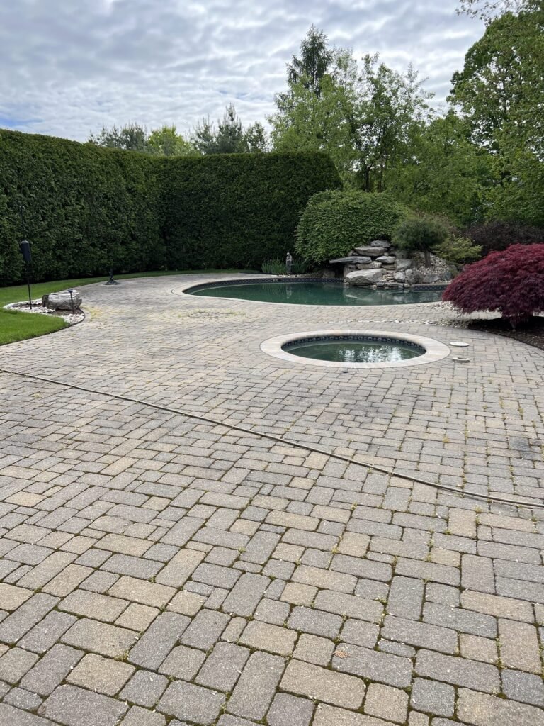 Before: weathered pool patio pavers before power washing