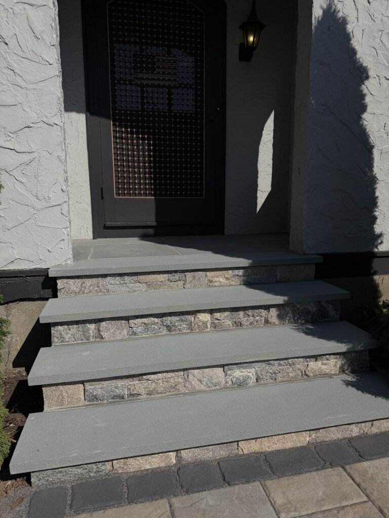 Bluestone vs. Concrete Pavers: Which Is Better for a Connecticut Patio? Bluestone front steps with stone veneer risers
