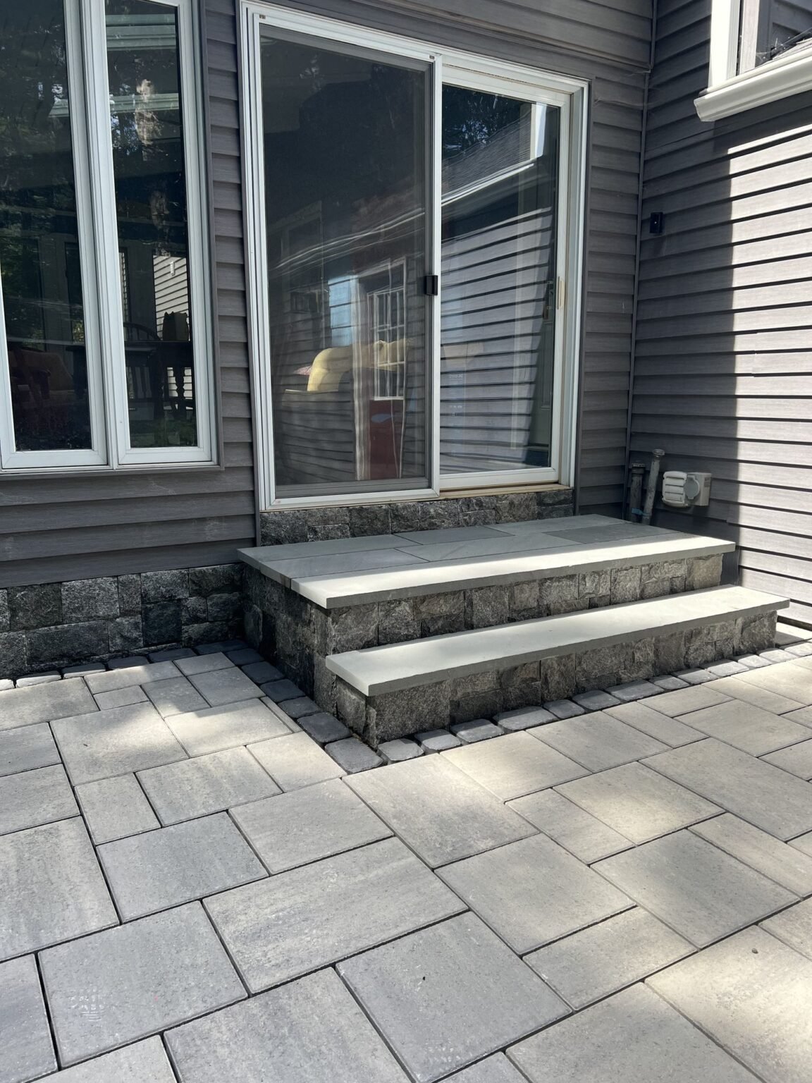 Bluestone steps with stone veneer risers on a slab patio in Simsbury, CT
