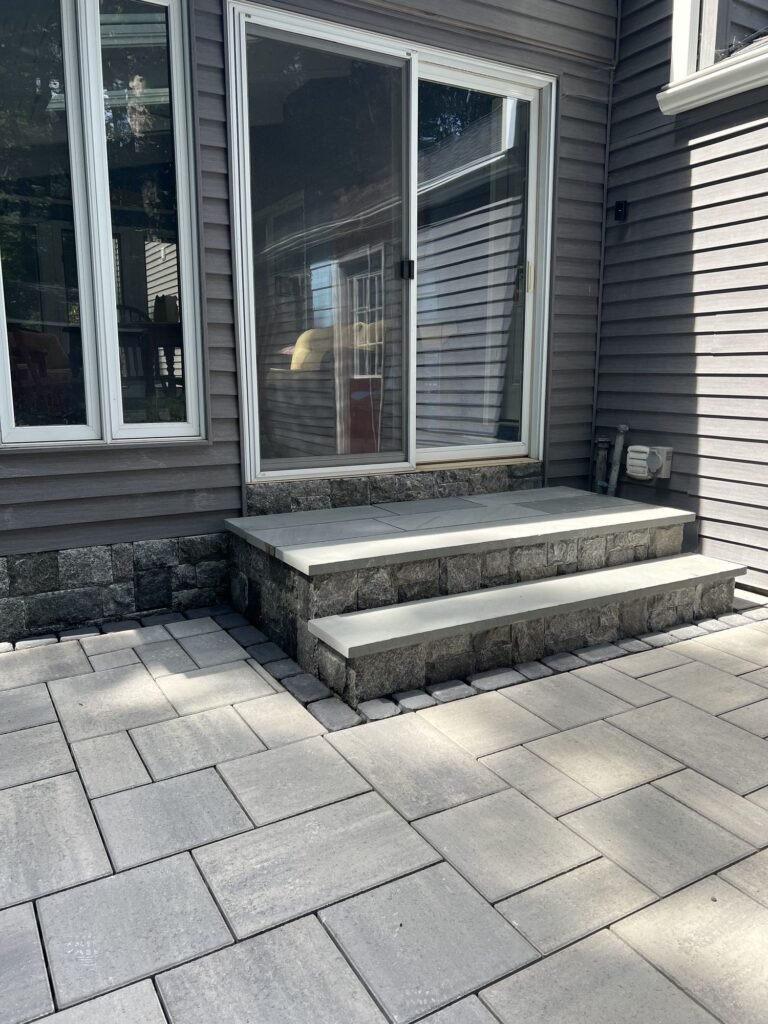 Bluestone steps with stone veneer risers on a slab patio in Simsbury, CT