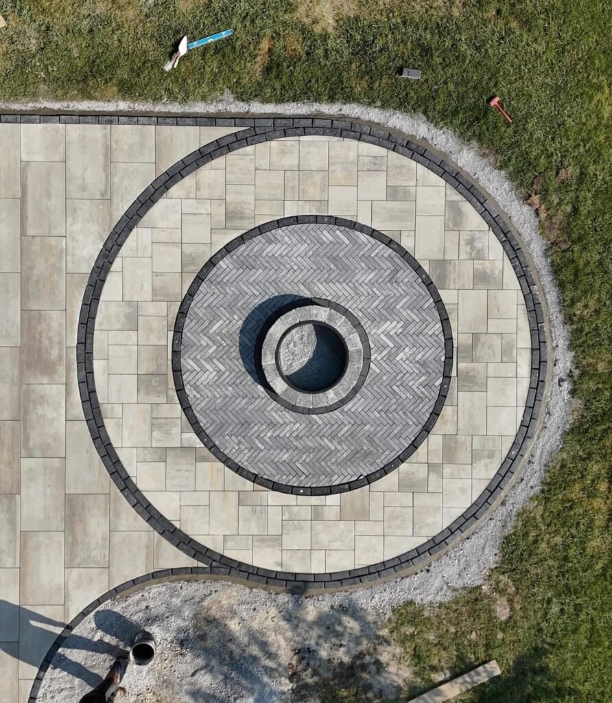 Overhead view of a circular fire pit patio with inlaid border rings in Wolcott, CT