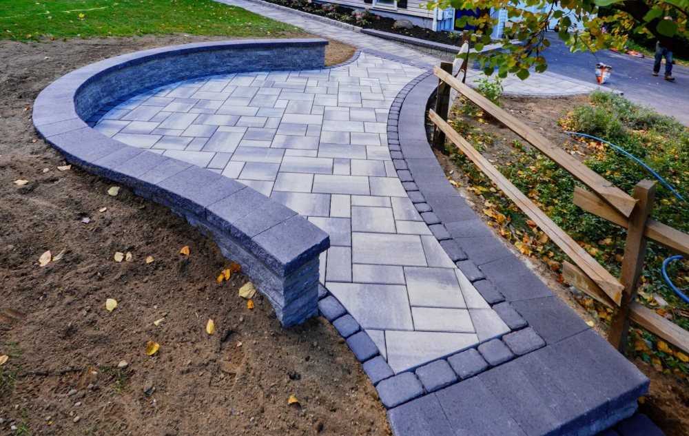 Curved paver patio with a curved seat wall and dark border