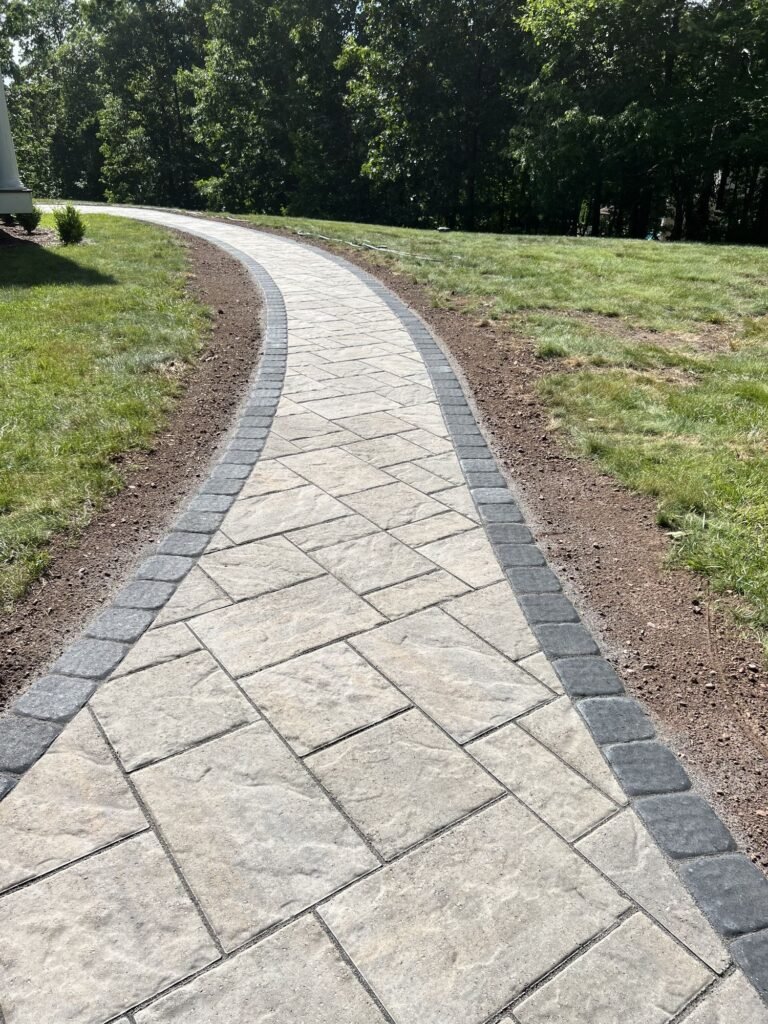 Long curved paver walkway with a dark border in Killingworth, CT