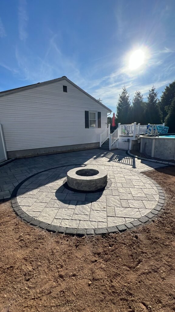 Backyard fire pit patio with a circular inlay in Wallingford, CT