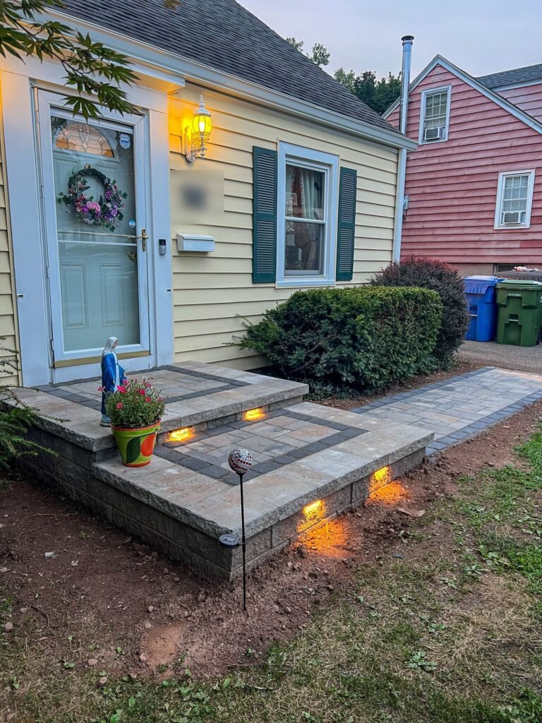 Paver front steps with built-in step lights and a matching walkway