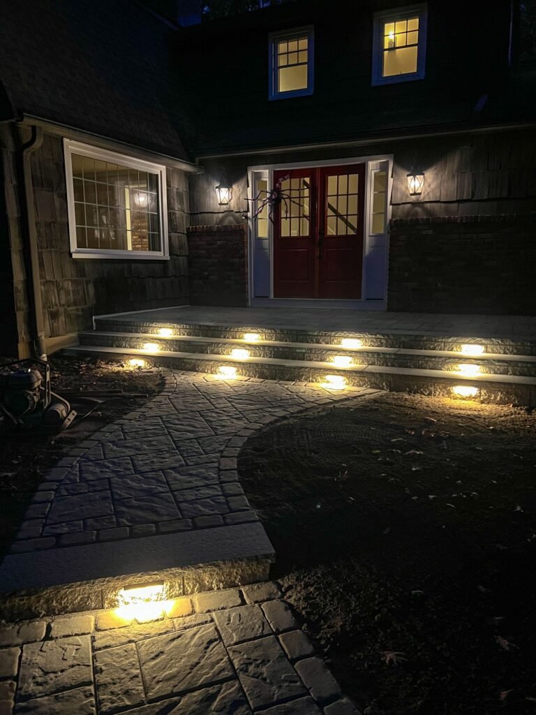 Lit front steps and paver walkway at night in Canton, CT
