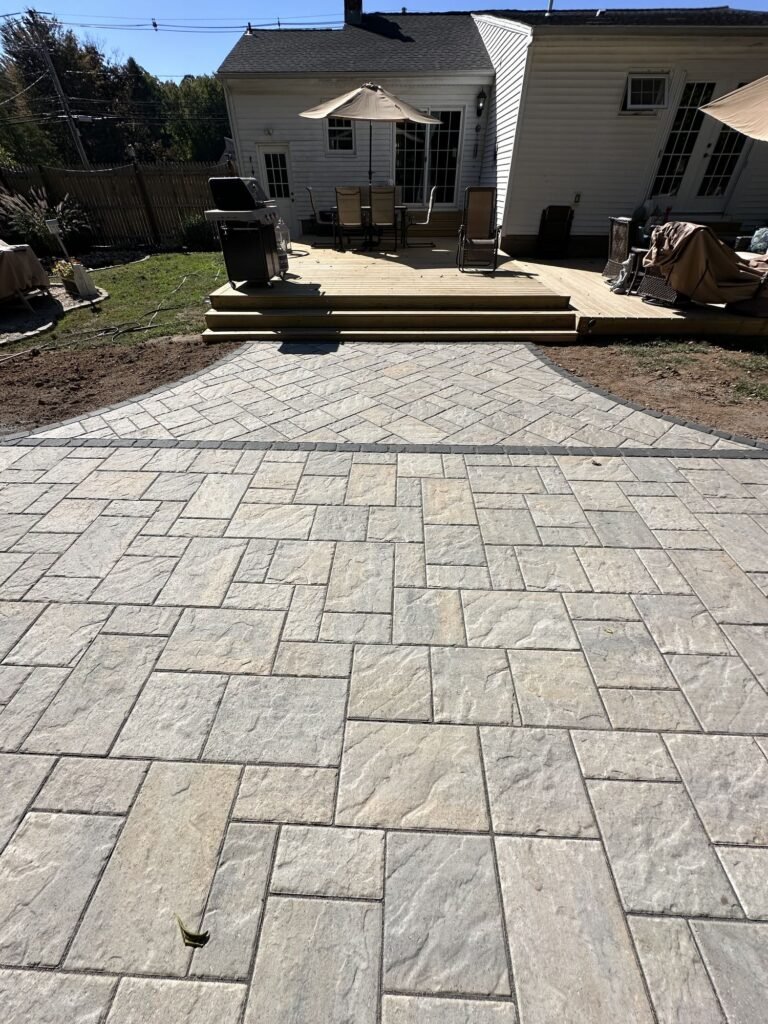 Large-format paver patio off a backyard deck