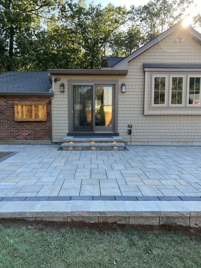 Large backyard paver patio with steps off the back door in Wallingford, CT