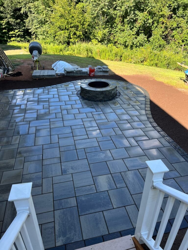 Paver patio with a built-in fire pit and dark border in Middletown, CT