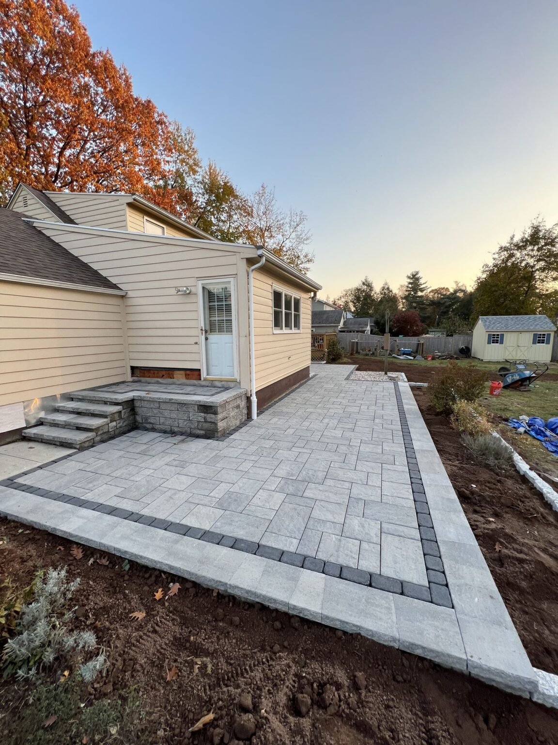 Backyard paver patio with stone veneer steps in North Haven, CT