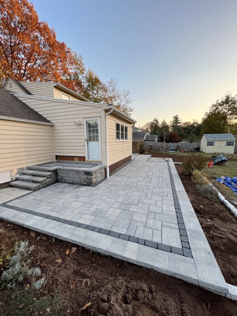 Backyard paver patio with stone veneer steps in North Haven, CT