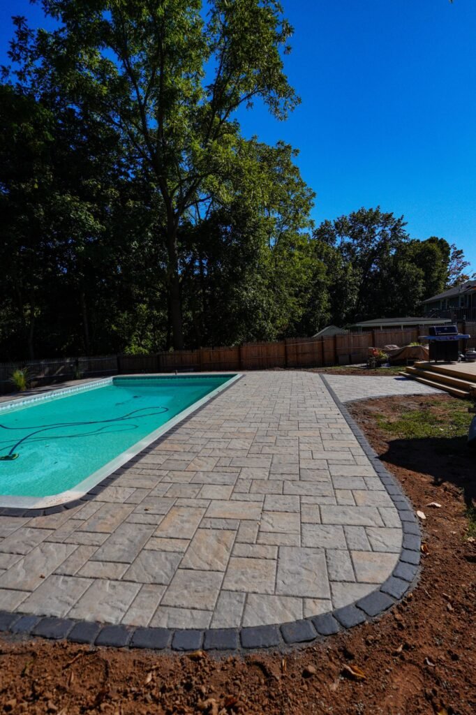 Curved paver pool deck border next to an in-ground pool in North Haven, CT
