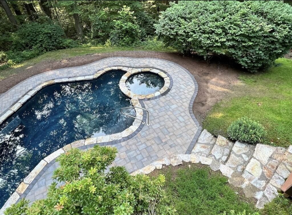Aerial view of a pool patio with natural stone and paver steps in Southington, CT