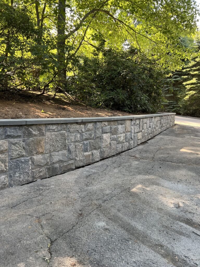 Stone-faced retaining wall along a driveway in Southington, CT